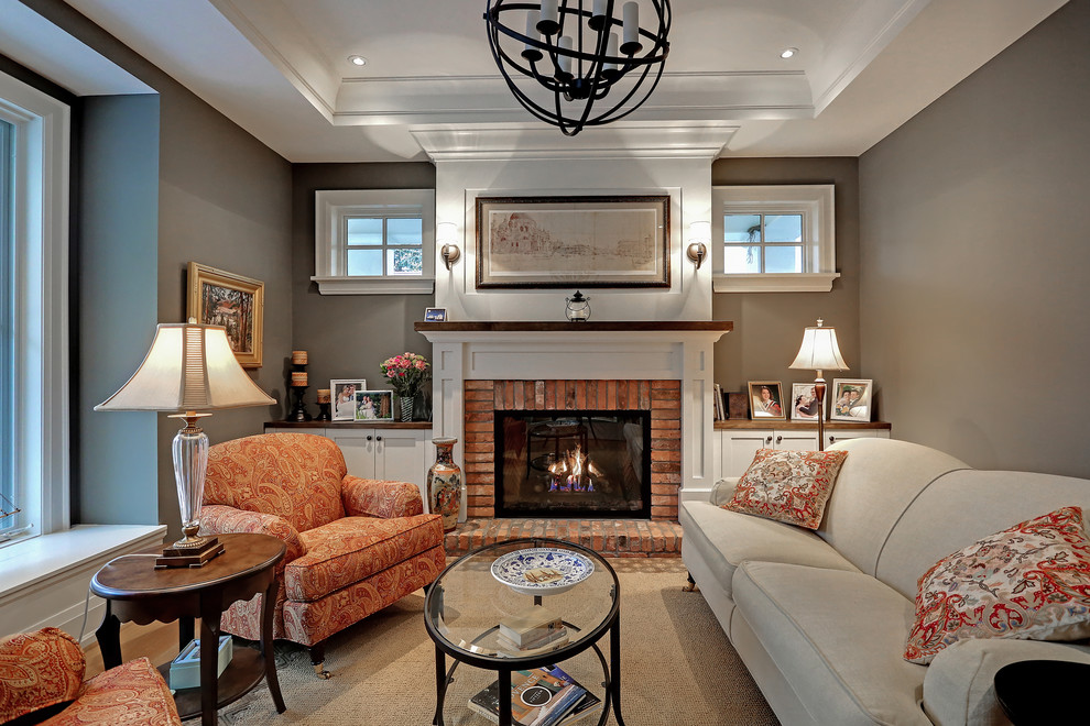 Photo of a traditional formal and grey and cream living room in Toronto with grey walls, carpet, a standard fireplace, a brick fireplace surround and no tv.