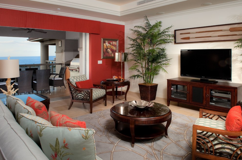 Immagine di un soggiorno tropicale aperto con pareti rosse, pavimento in pietra calcarea e TV autoportante