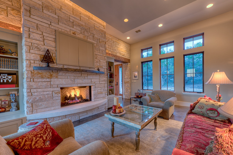 Example of a mid-sized eclectic open concept concrete floor and brown floor living room design in Austin with a standard fireplace, a stone fireplace, beige walls and a concealed tv