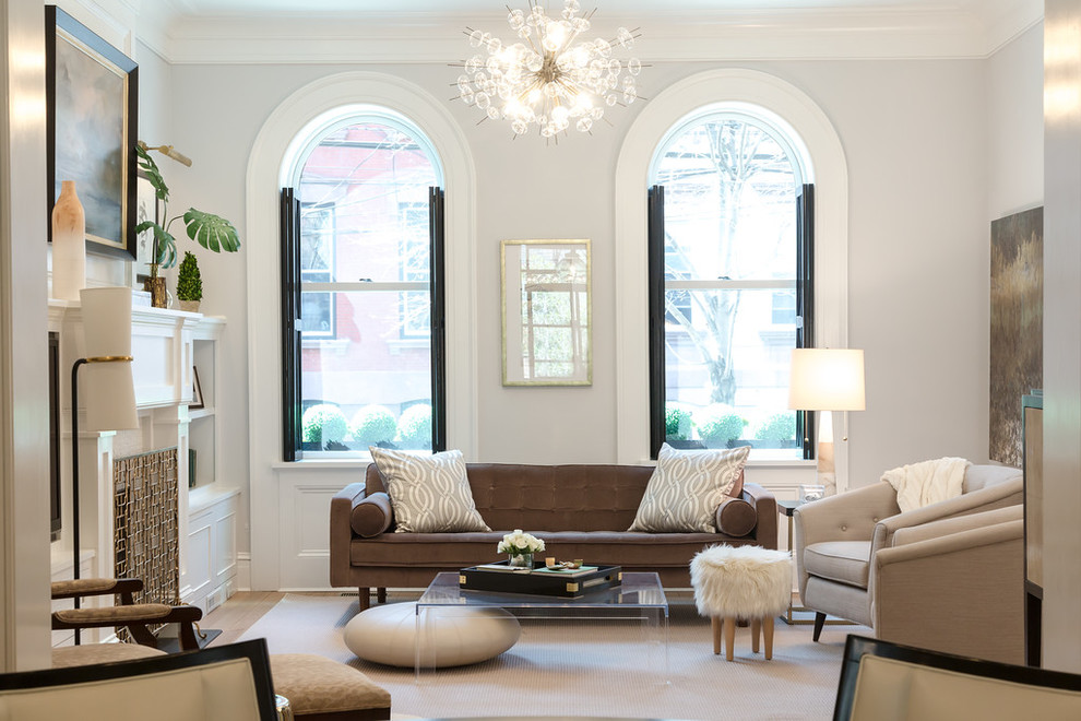 This is an example of a traditional formal enclosed living room in Newark with light hardwood flooring, a standard fireplace, a wooden fireplace surround, grey walls and beige floors.