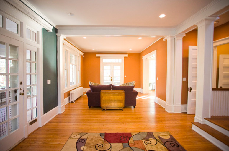 Modern inredning av ett mellanstort allrum med öppen planlösning, med orange väggar, ljust trägolv och brunt golv
