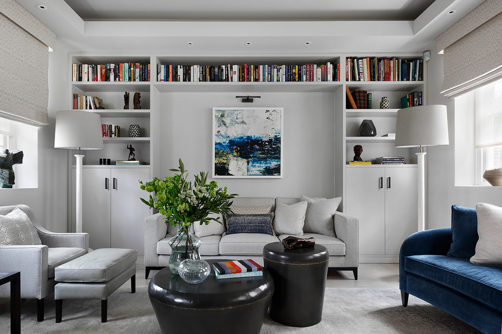 Immagine di un soggiorno contemporaneo con libreria, pareti bianche e pavimento in cemento