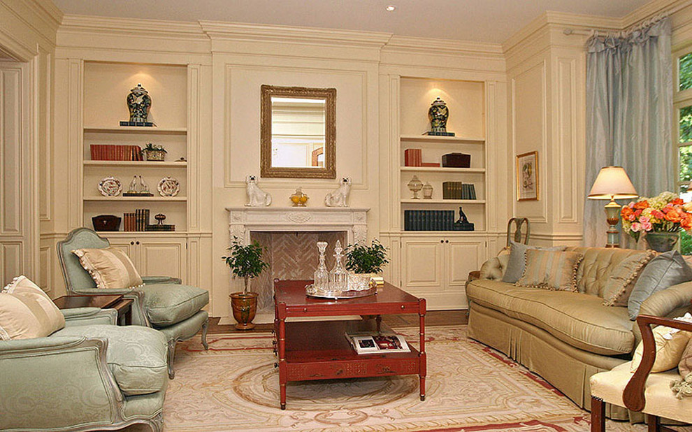 Example of a mid-sized classic formal and enclosed medium tone wood floor living room design in Toronto with beige walls, a standard fireplace and a plaster fireplace