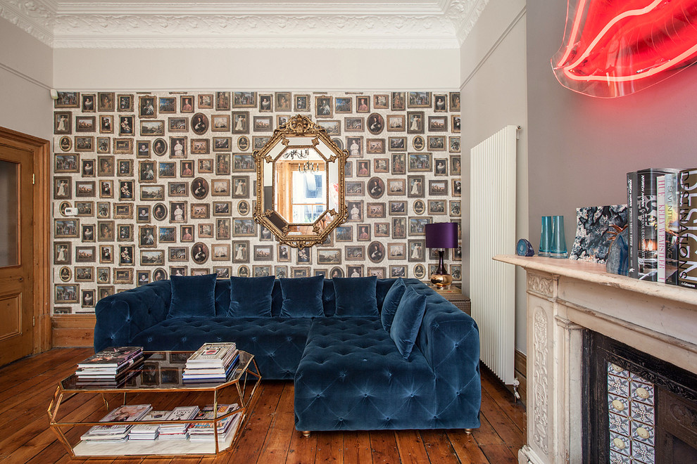 Eclectic living room in London with grey walls, medium hardwood flooring, a standard fireplace and a stone fireplace surround.