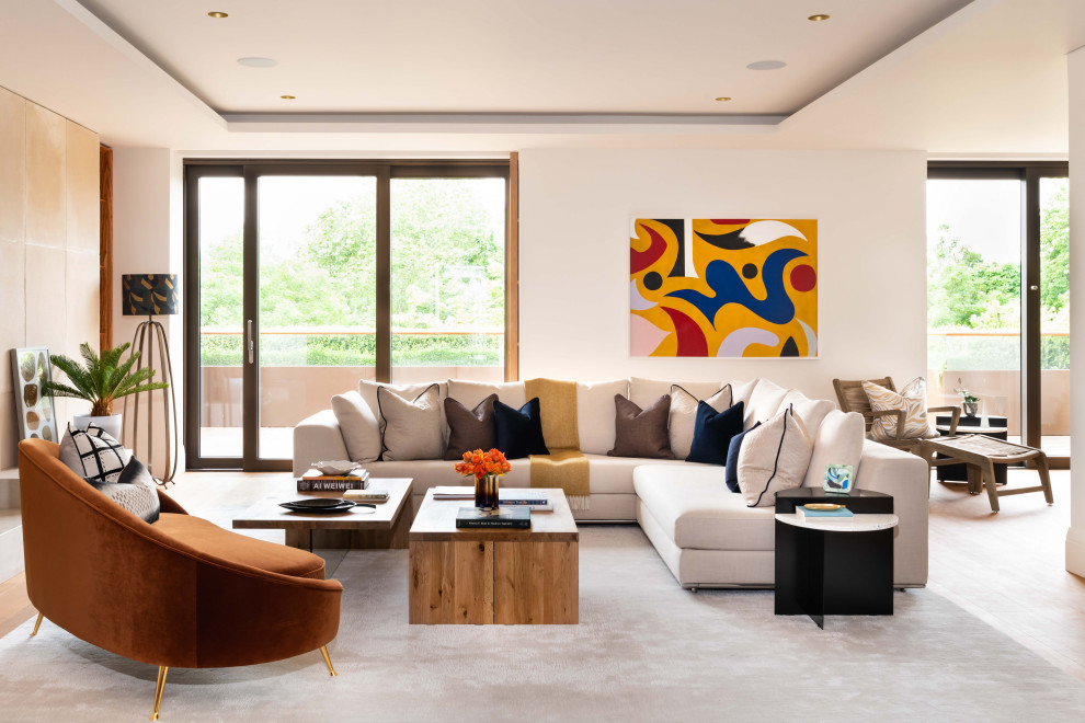Example of a trendy open concept medium tone wood floor, brown floor and tray ceiling living room design in London with white walls