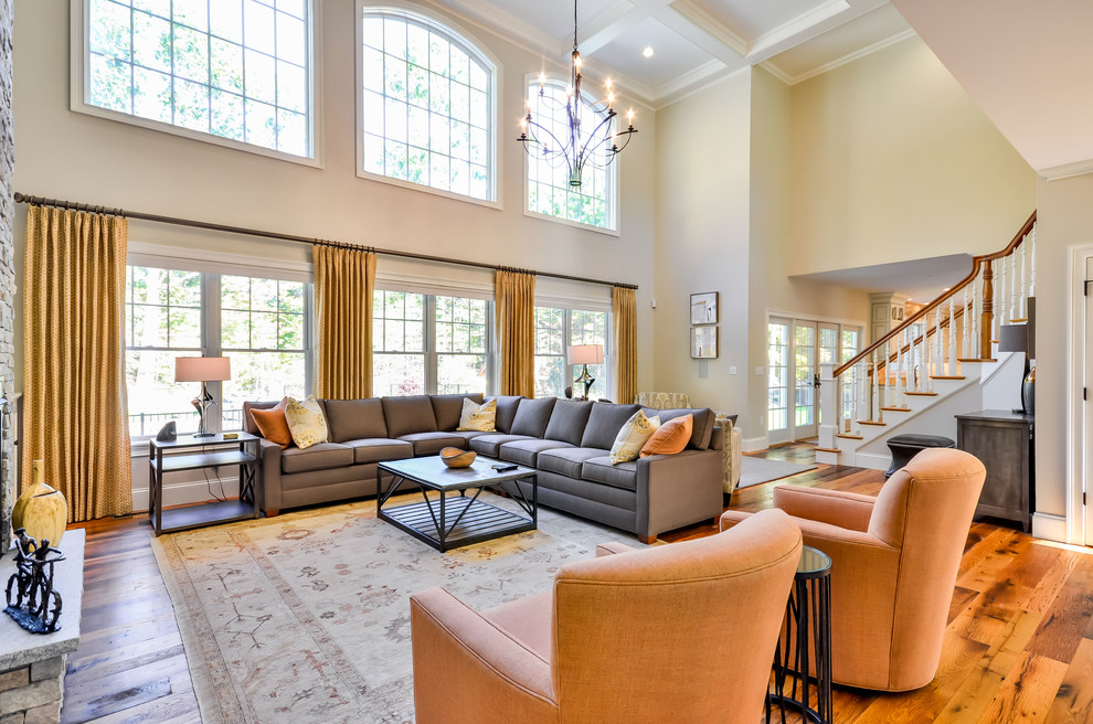 Immagine di un ampio soggiorno classico aperto con pareti beige e pavimento in legno massello medio