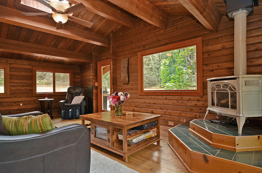 Large rustic open plan living room in Seattle with medium hardwood flooring, a wood burning stove and no tv.