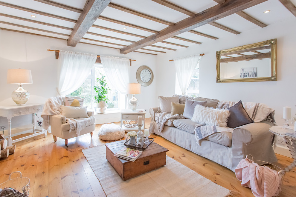 Abgetrenntes Nordisches Wohnzimmer mit weißer Wandfarbe, braunem Holzboden und braunem Boden in West Midlands