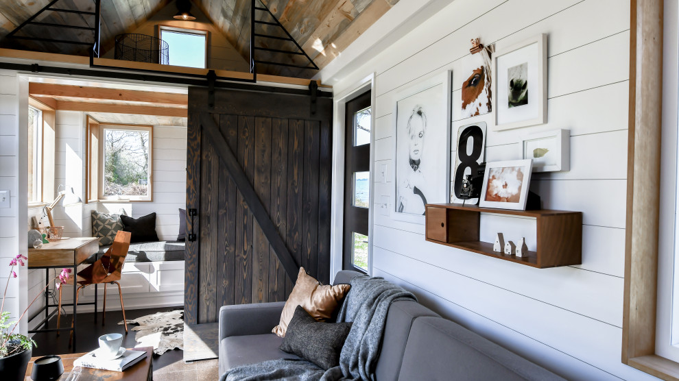 Modelo de salón tipo loft de estilo de casa de campo pequeño con paredes blancas, suelo de corcho, suelo negro, machihembrado y machihembrado