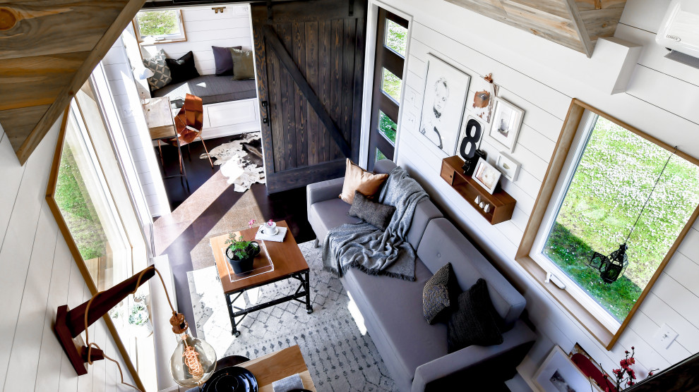На фото: маленькая двухуровневая гостиная комната в стиле кантри с белыми стенами, пробковым полом, черным полом, потолком из вагонки и стенами из вагонки для на участке и в саду