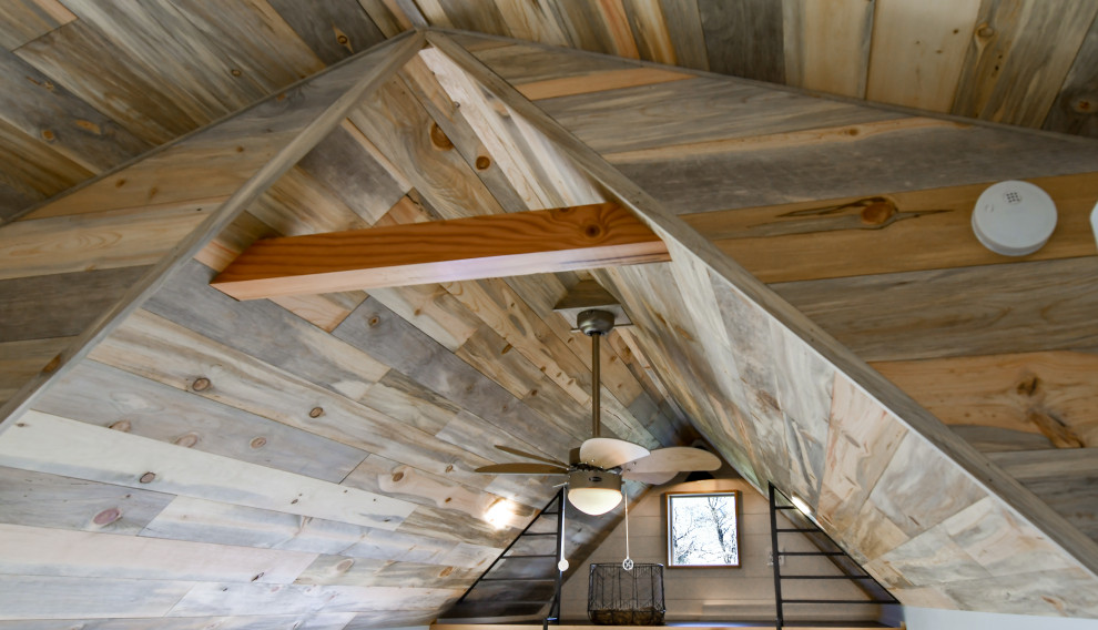 Foto di un piccolo soggiorno country stile loft con pareti bianche, pavimento in sughero, pavimento nero, soffitto in perlinato e pareti in perlinato