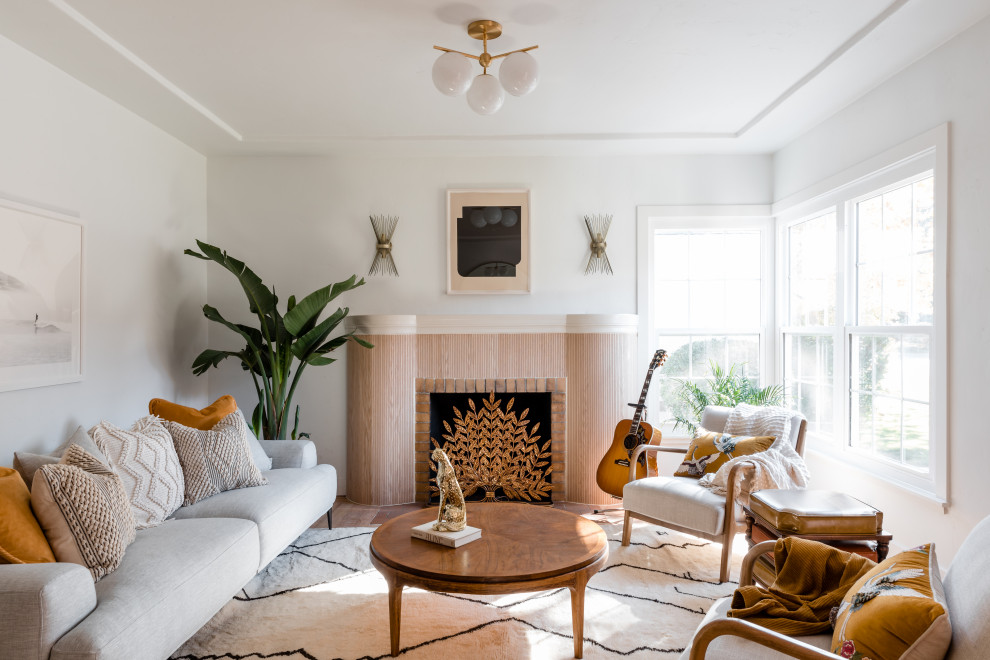 Offenes Maritimes Wohnzimmer mit weißer Wandfarbe, hellem Holzboden, Kamin, Kaminumrandung aus Holz und beigem Boden in Sacramento