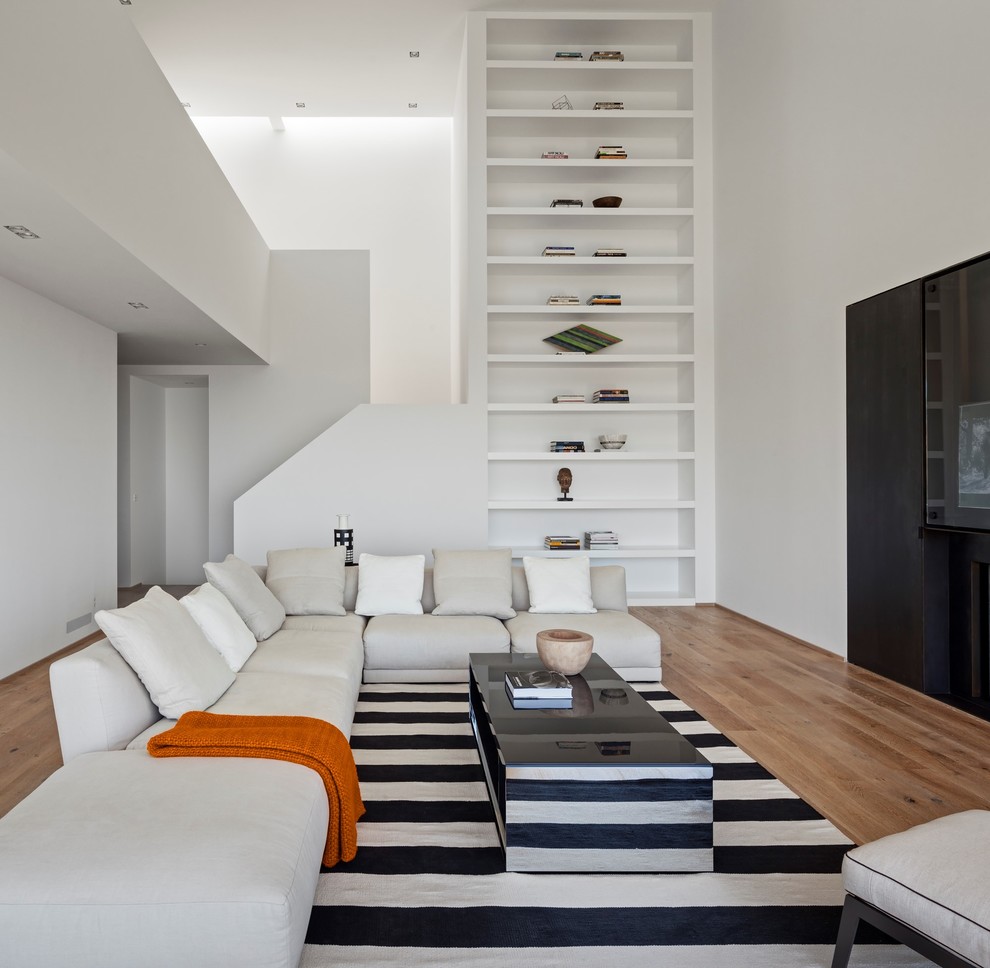 Идея дизайна: гостиная комната в стиле модернизм с белыми стенами, паркетным полом среднего тона и коричневым полом