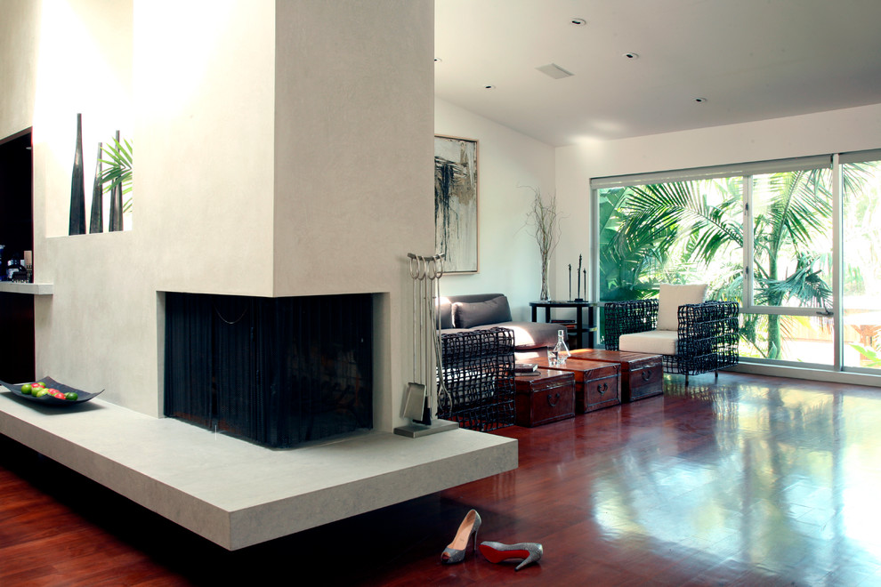 Mittelgroßes, Repräsentatives, Fernseherloses, Offenes Modernes Wohnzimmer mit beiger Wandfarbe, dunklem Holzboden, Eckkamin und verputzter Kaminumrandung in Los Angeles
