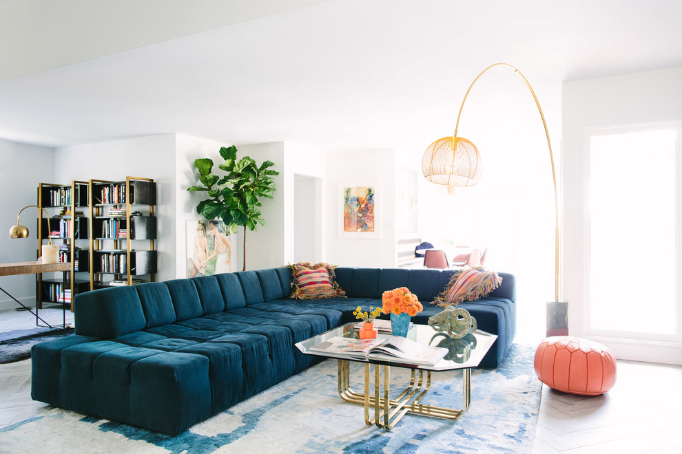На фото: гостиная комната в современном стиле с белыми стенами и синим диваном с