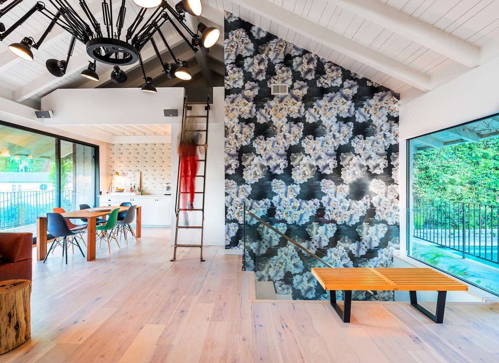 Kleines Eklektisches Wohnzimmer im Loft-Stil mit bunten Wänden, hellem Holzboden, Eckkamin, verputzter Kaminumrandung und TV-Wand in Los Angeles