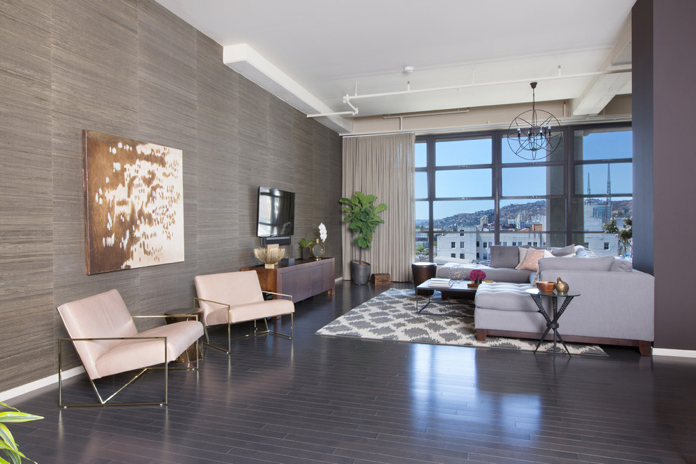 Mittelgroßes Industrial Wohnzimmer ohne Kamin, im Loft-Stil mit Hausbar, grauer Wandfarbe, dunklem Holzboden und TV-Wand in Los Angeles