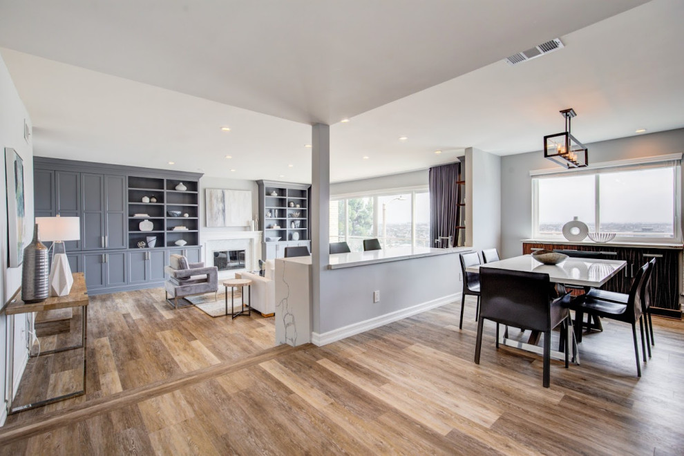 Example of a transitional open concept vinyl floor and brown floor living room design in Los Angeles with a bar