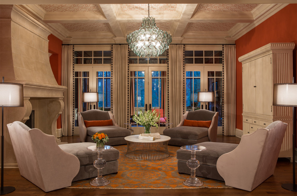 Idée de décoration pour un très grand salon tradition ouvert avec une salle de musique, un mur orange, un sol en bois brun, une cheminée standard, un manteau de cheminée en pierre, un téléviseur dissimulé et un sol marron.