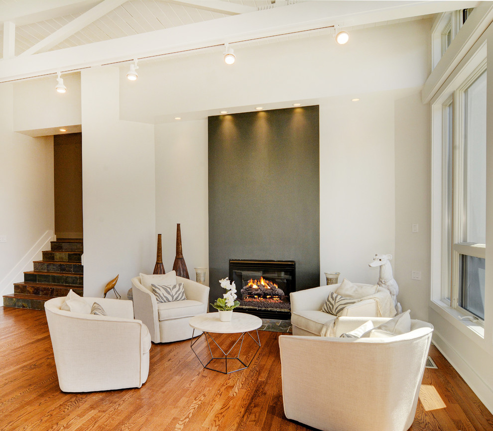 Diseño de salón para visitas abierto tradicional renovado grande sin televisor con paredes blancas, suelo de madera en tonos medios y todas las chimeneas