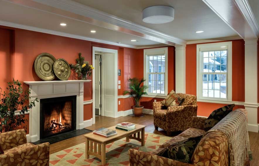 Exemple d'un grand salon chic fermé avec un mur rouge, une cheminée standard, un manteau de cheminée en bois et un sol marron.