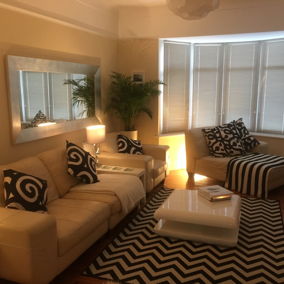 Mittelgroßes, Repräsentatives, Abgetrenntes Modernes Wohnzimmer mit beiger Wandfarbe, Kaminumrandung aus Holz und freistehendem TV in Devon