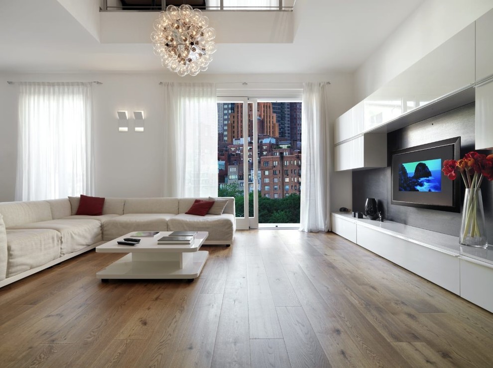 Ejemplo de salón abierto moderno grande sin chimenea con paredes blancas, suelo de madera en tonos medios, televisor colgado en la pared y suelo marrón