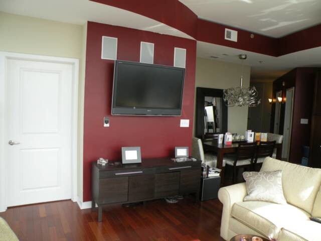 Ejemplo de salón abierto contemporáneo de tamaño medio con paredes blancas, suelo de madera oscura, televisor colgado en la pared y suelo marrón