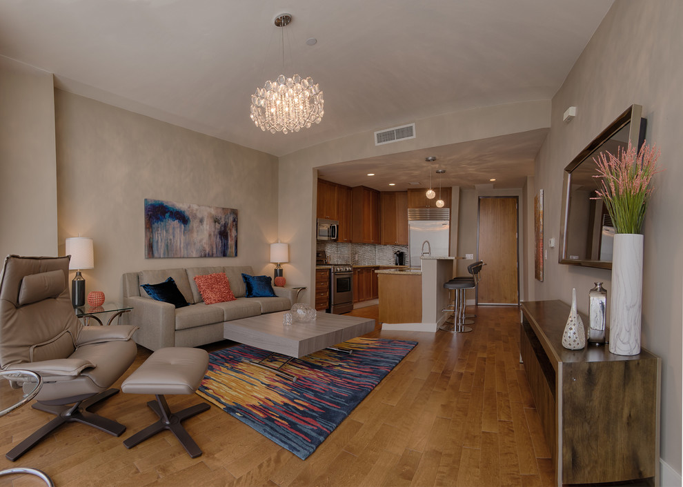 Источник вдохновения для домашнего уюта: двухуровневая гостиная комната среднего размера в современном стиле с бежевыми стенами, паркетным полом среднего тона и телевизором на стене