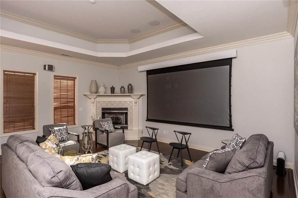 Стильный дизайн: большая гостиная комната в современном стиле с серыми стенами, паркетным полом среднего тона, угловым камином, фасадом камина из плитки, телевизором на стене и коричневым полом - последний тренд