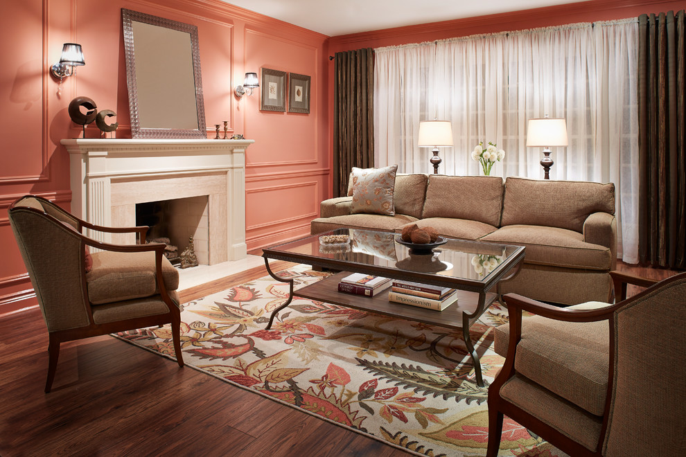 Exempel på ett mellanstort klassiskt separat vardagsrum, med ett finrum, rosa väggar, mörkt trägolv, en standard öppen spis, en spiselkrans i sten och brunt golv