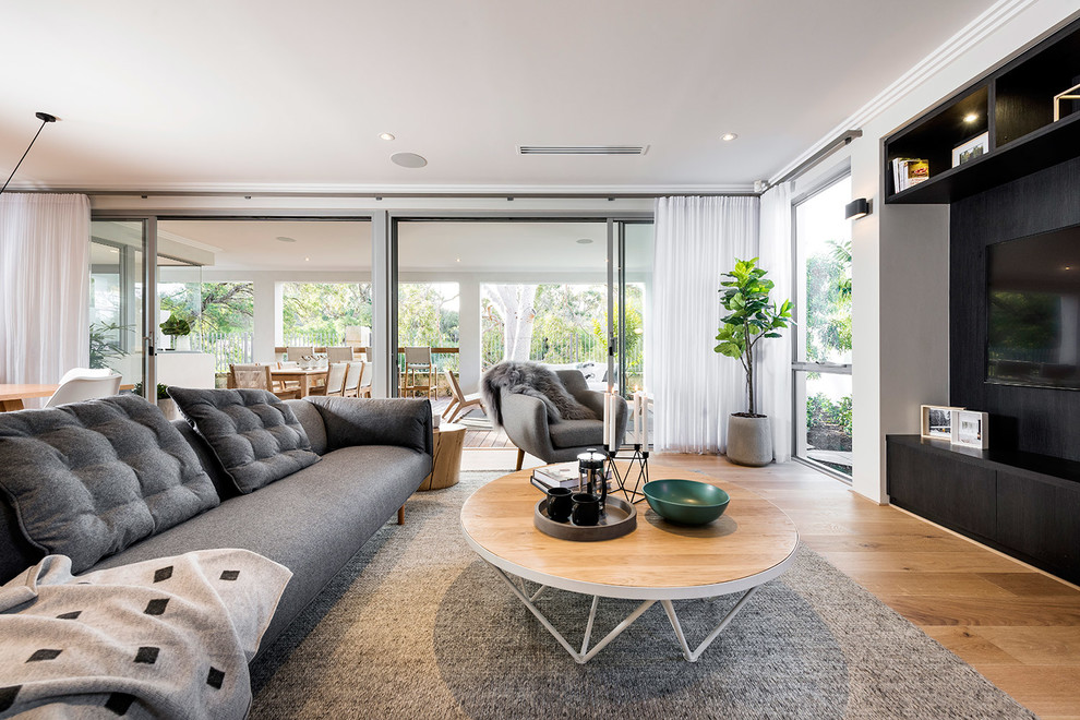 Offenes Modernes Wohnzimmer mit grauer Wandfarbe, hellem Holzboden und TV-Wand in Perth