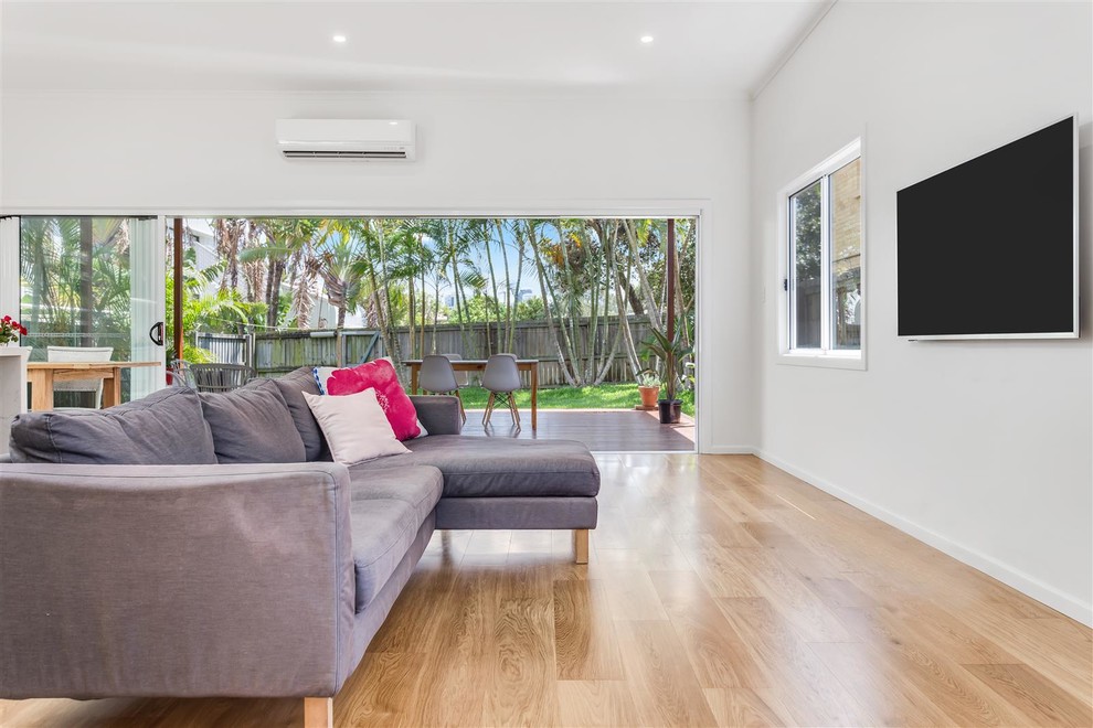 Großes, Offenes Modernes Wohnzimmer mit grauer Wandfarbe, hellem Holzboden und TV-Wand in Gold Coast - Tweed