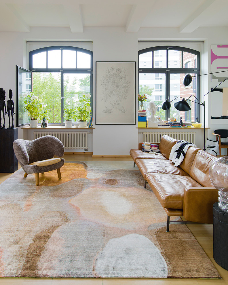 Idee per un soggiorno minimal con pareti bianche, parquet chiaro e pavimento beige