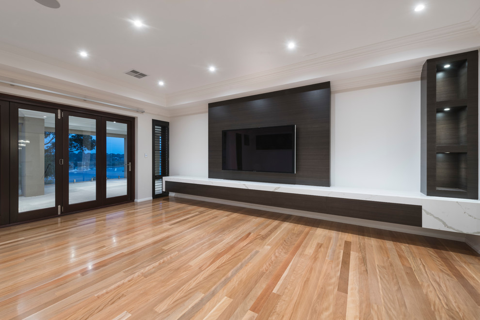 Inspiration for an expansive contemporary open plan living room in Perth with a reading nook, grey walls, medium hardwood flooring, a wall mounted tv and brown floors.