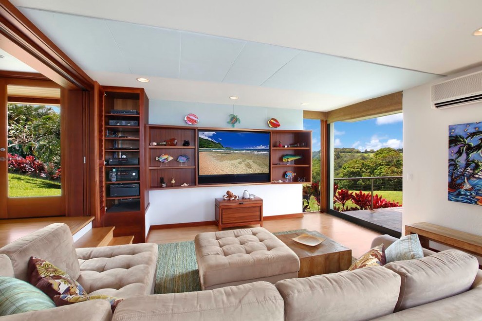 Design ideas for a large world-inspired open plan living room in Hawaii with white walls, medium hardwood flooring, no fireplace, a wall mounted tv and brown floors.