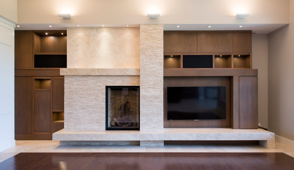 Example of a large transitional enclosed dark wood floor living room design in Edmonton with multicolored walls, a standard fireplace, a stone fireplace and a media wall