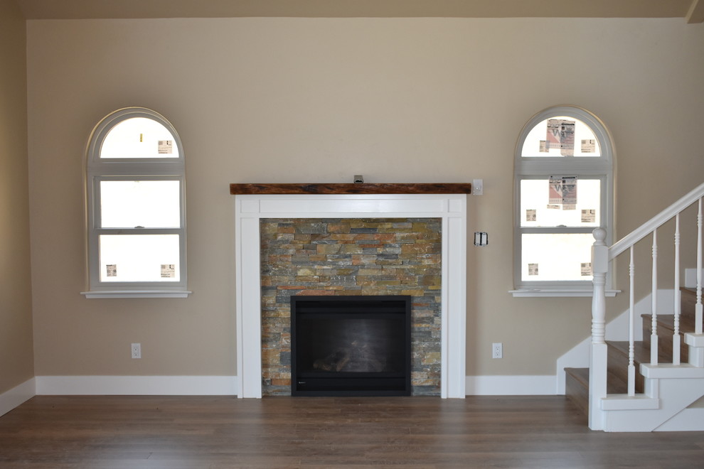 This is an example of a medium sized classic open plan living room in Other with beige walls, laminate floors, a standard fireplace, a brick fireplace surround and brown floors.