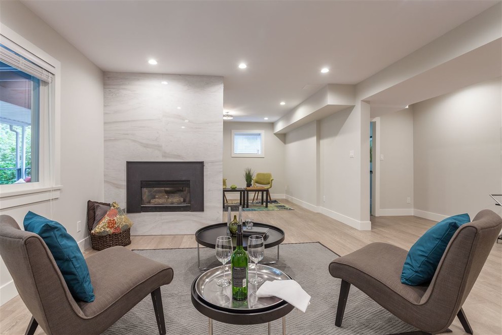 Источник вдохновения для домашнего уюта: открытая гостиная комната среднего размера в стиле модернизм с серыми стенами, паркетным полом среднего тона, стандартным камином и фасадом камина из плитки