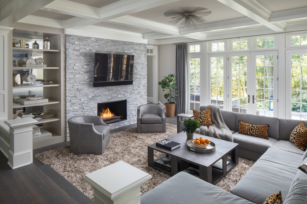 Inspiration for a transitional open concept dark wood floor, brown floor and coffered ceiling living room remodel in Philadelphia with gray walls, a standard fireplace, a stacked stone fireplace and a wall-mounted tv