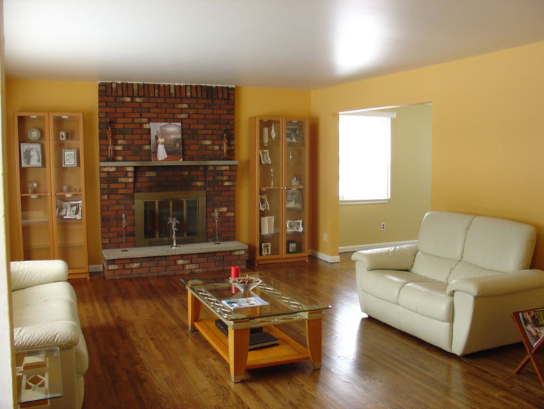 Свежая идея для дизайна: открытая гостиная комната среднего размера в современном стиле с желтыми стенами, паркетным полом среднего тона, стандартным камином и фасадом камина из кирпича без телевизора - отличное фото интерьера