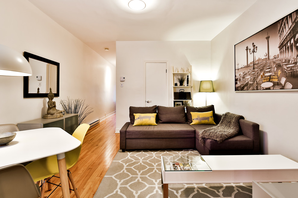 Ejemplo de salón abierto contemporáneo pequeño con paredes beige, suelo de madera en tonos medios y televisor colgado en la pared