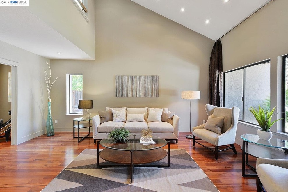 Imagen de salón para visitas cerrado actual de tamaño medio con paredes beige y suelo de madera en tonos medios