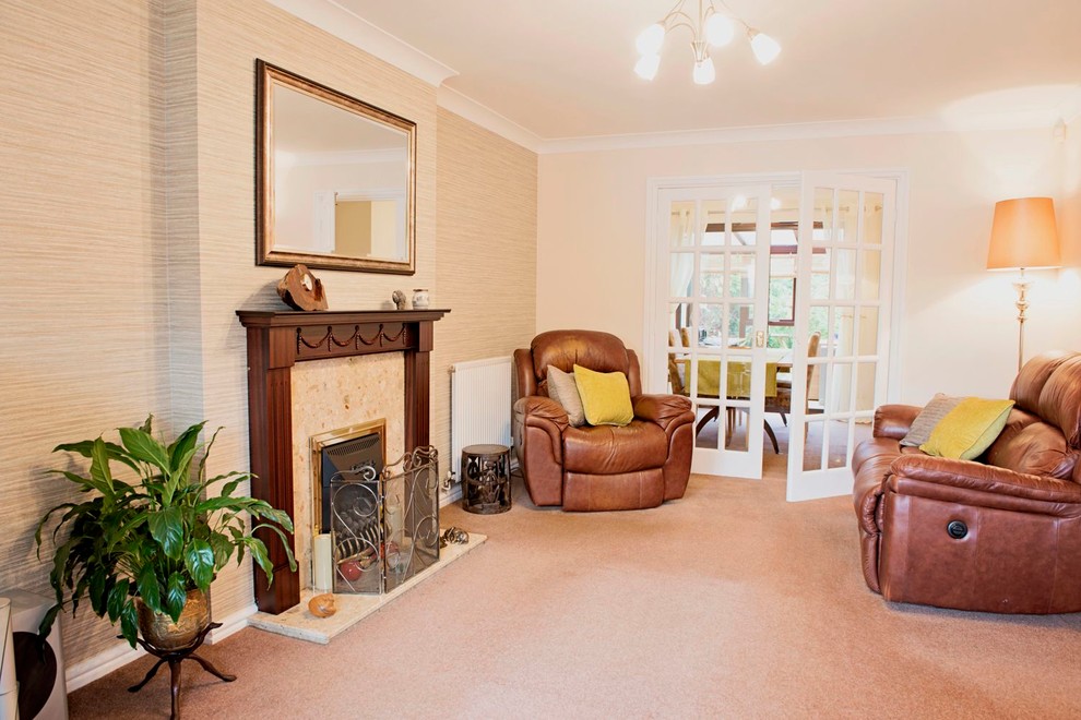 Exemple d'un salon tendance fermé et de taille moyenne avec un mur beige, moquette, une cheminée standard, un manteau de cheminée en bois et un téléviseur indépendant.