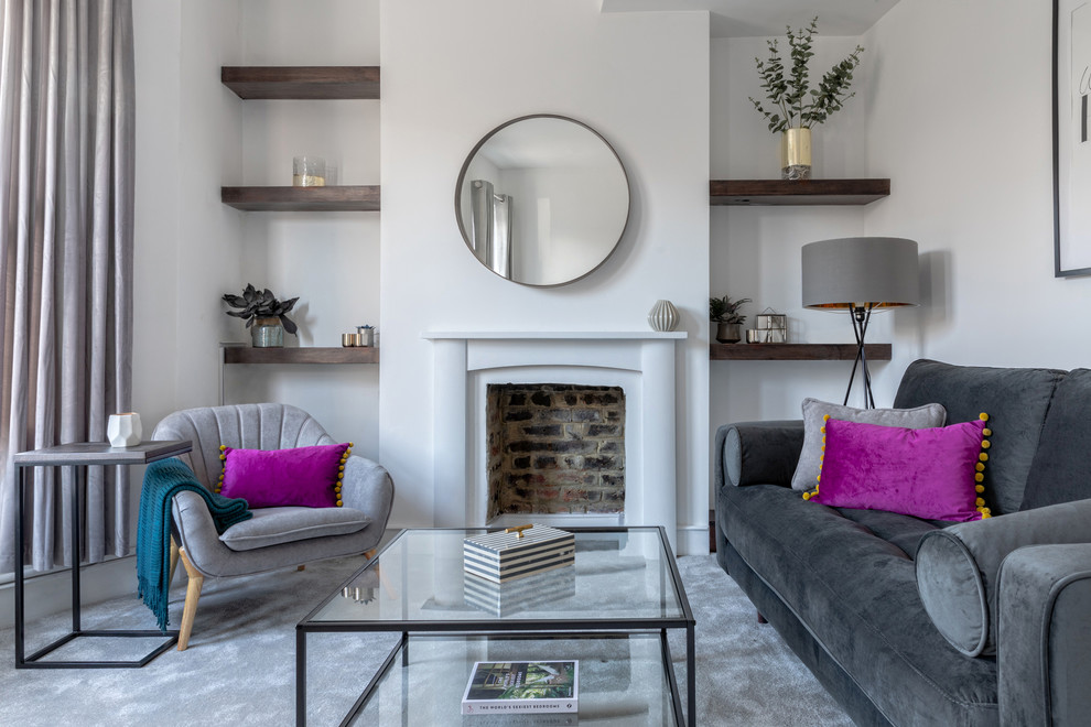 ロンドンにあるトランジショナルスタイルのおしゃれなリビング (白い壁、カーペット敷き、標準型暖炉、石材の暖炉まわり、グレーの床) の写真