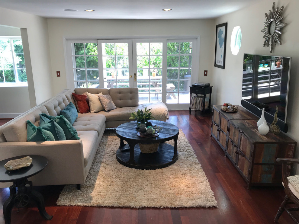 Mittelgroßes, Offenes Stilmix Wohnzimmer ohne Kamin mit grauer Wandfarbe, braunem Holzboden, TV-Wand und braunem Boden in Los Angeles