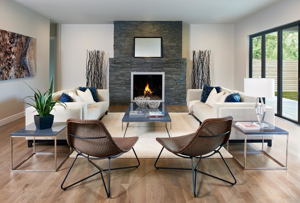Großes, Abgetrenntes Modernes Wohnzimmer mit weißer Wandfarbe, braunem Holzboden, Kamin und Kaminumrandung aus Stein in Denver