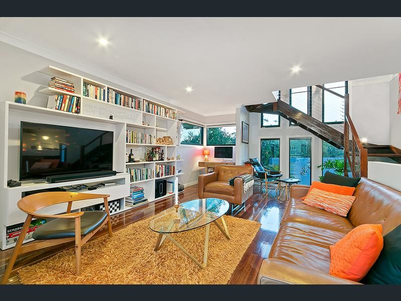 Großes, Abgetrenntes Retro Wohnzimmer ohne Kamin mit weißer Wandfarbe, braunem Holzboden und Multimediawand in Brisbane