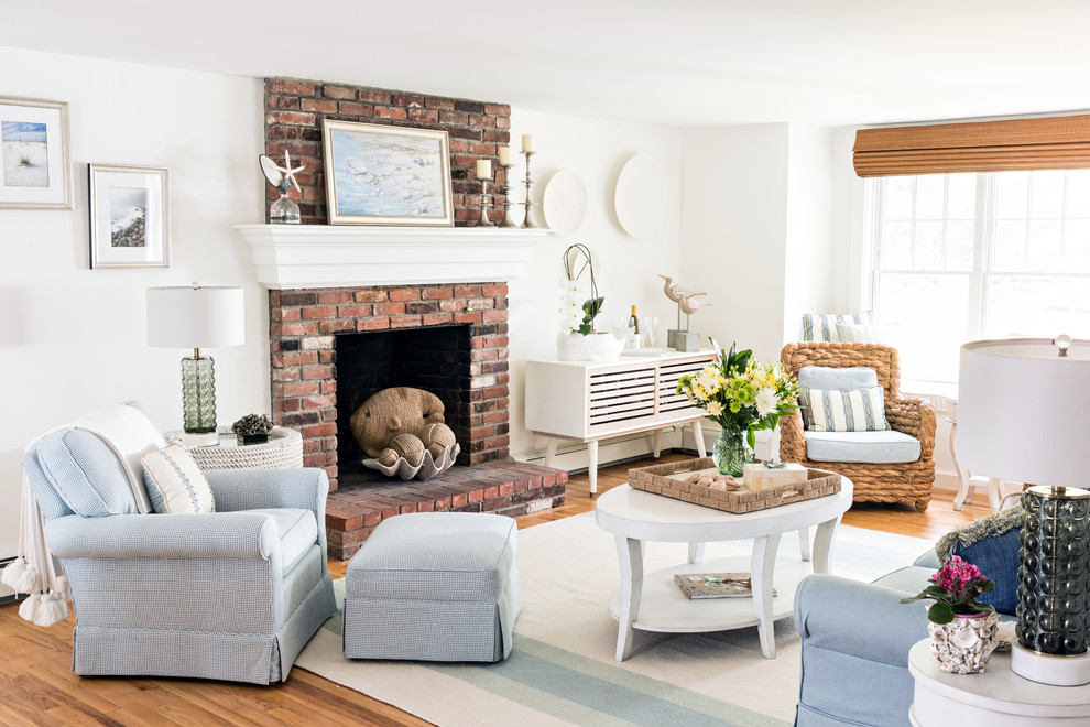 Maritimes Wohnzimmer mit weißer Wandfarbe, braunem Holzboden, Kamin, Kaminumrandung aus Backstein und braunem Boden in Boston