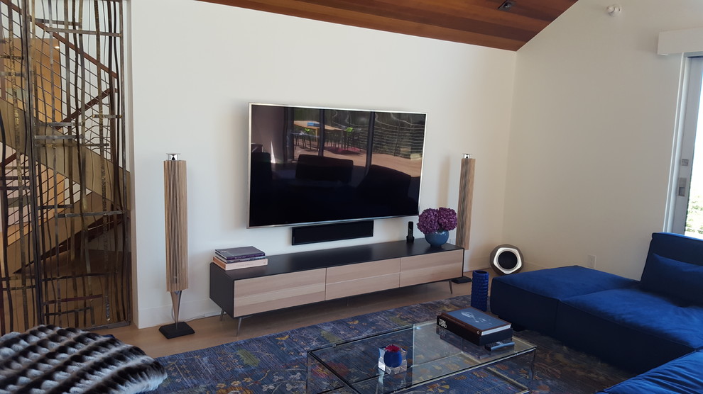 Immagine di un soggiorno minimalista di medie dimensioni e chiuso con TV a parete, pareti beige, parquet chiaro, nessun camino e pavimento marrone